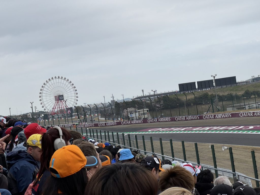 2025年F1第3戦日本GP［DAY-3］決勝日のG席(130R)。満席の観客席越しに観覧車が見えます。