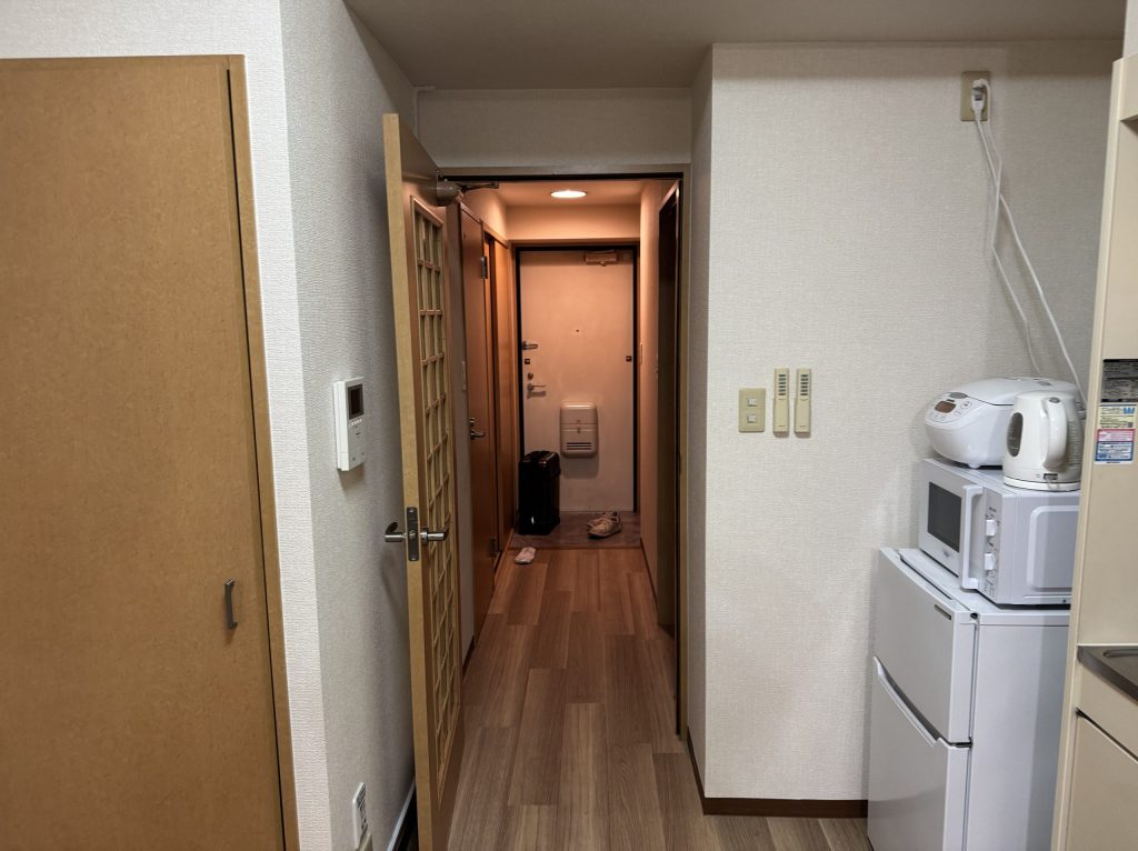 2025年4月に宿泊したウィークリーマンション。1Kの間取り。キッチンから玄関方面の画像。