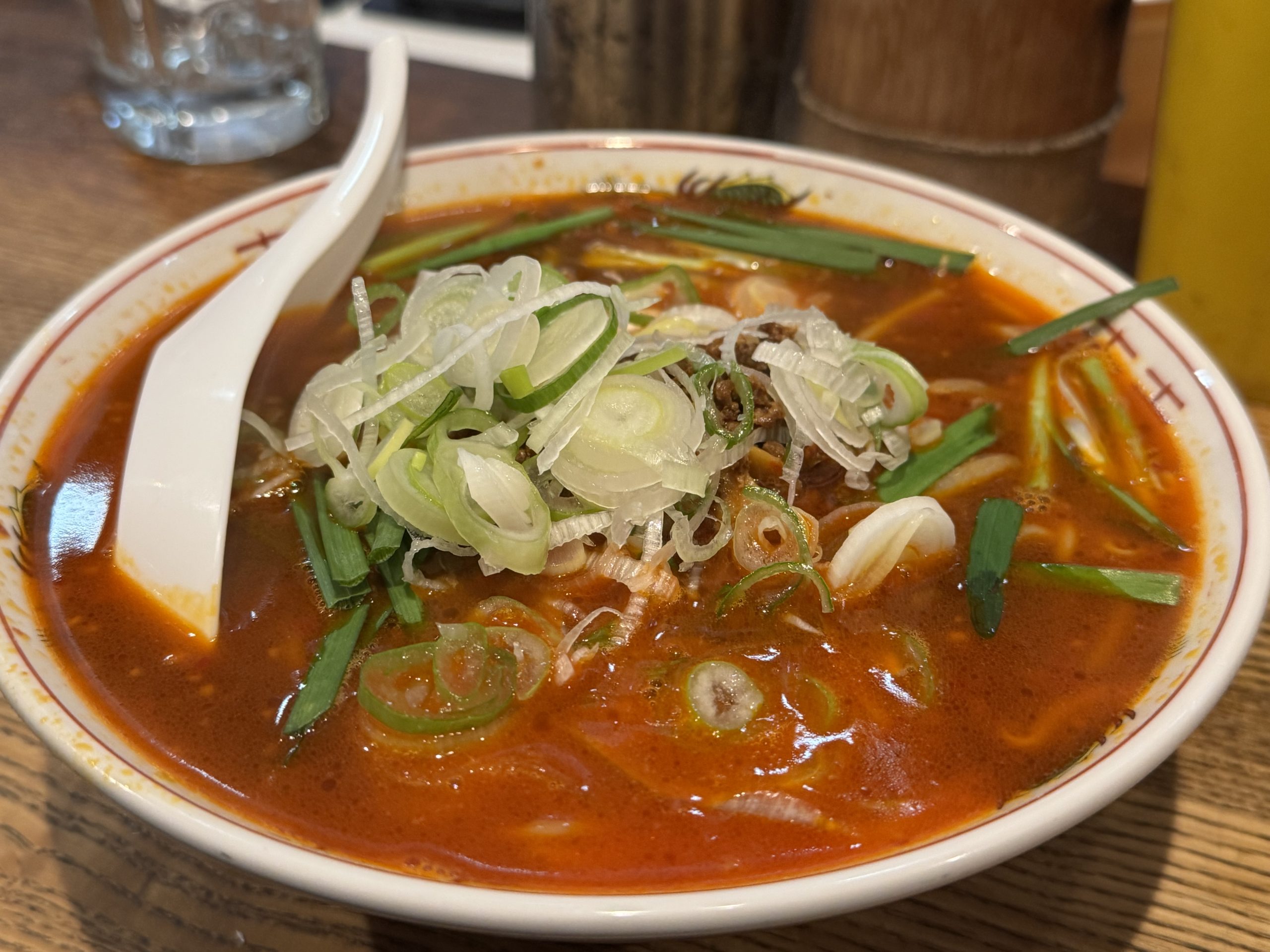 山甲の台湾ラーメン。赤みのあるスープにネギとニラがたっぷり乗る一杯。
