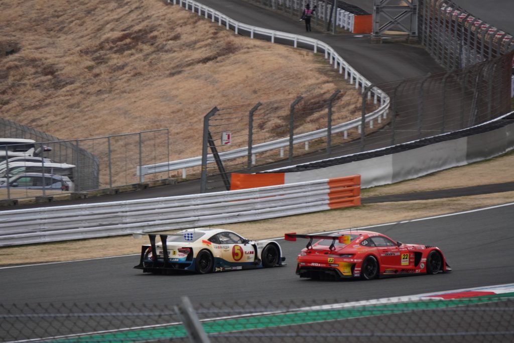 2ワイド(サイドバイサイド)でヘアピンを抜けていく#5 マッハ車検 エアバスター MC86 マッハ号と#22 アールキューズ AMG GT3